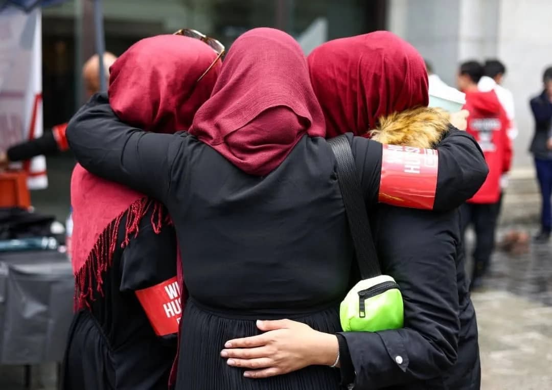 Community members embracing at a Muharram commemoration.
