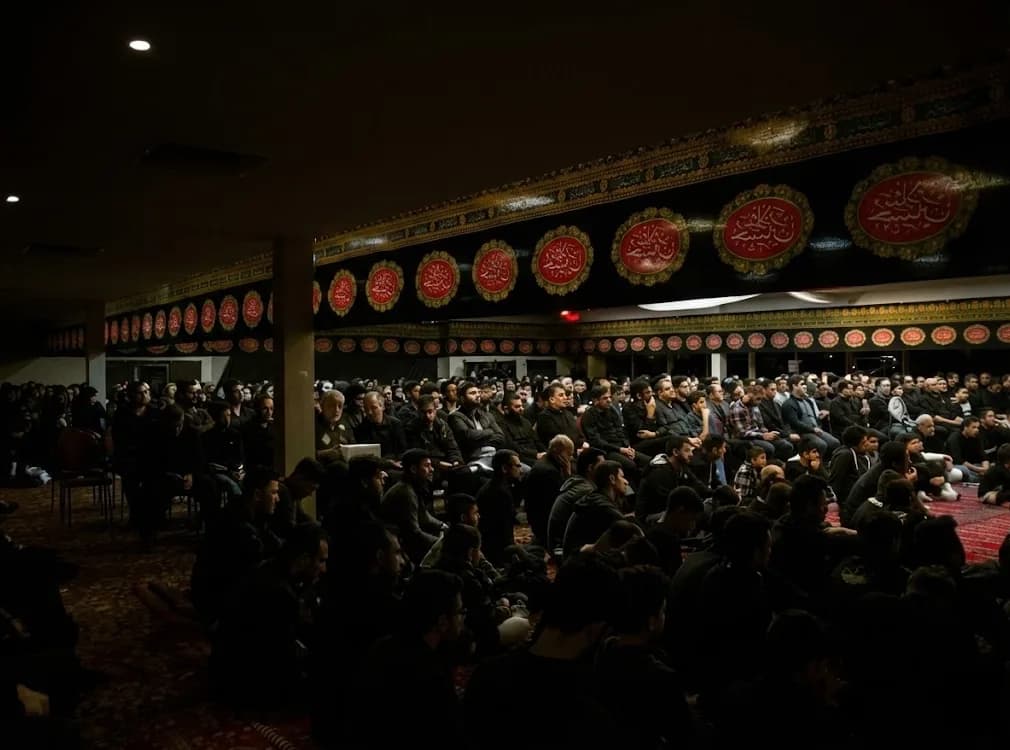 Community members seated together at a majlis in the centre's hall.